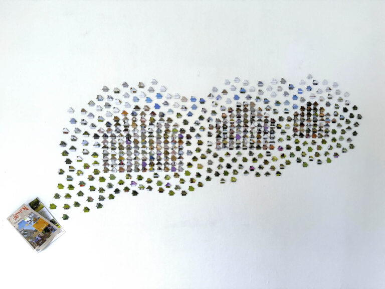 vooraanzicht van huisjes gevouwen van het magazine buitenwonen op een witte muur